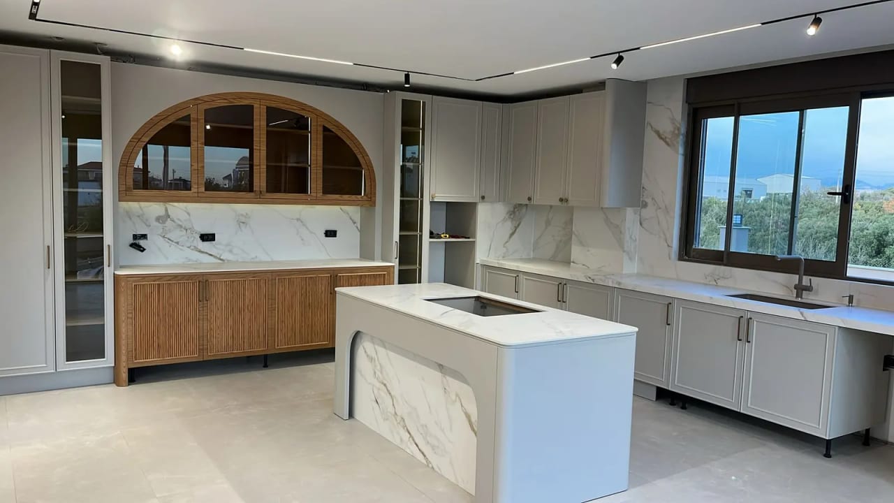 Ada tezgâhı ve kemerli ahşap dolaplarıyla villa mutfağı; proje arşivinden fotoğraf